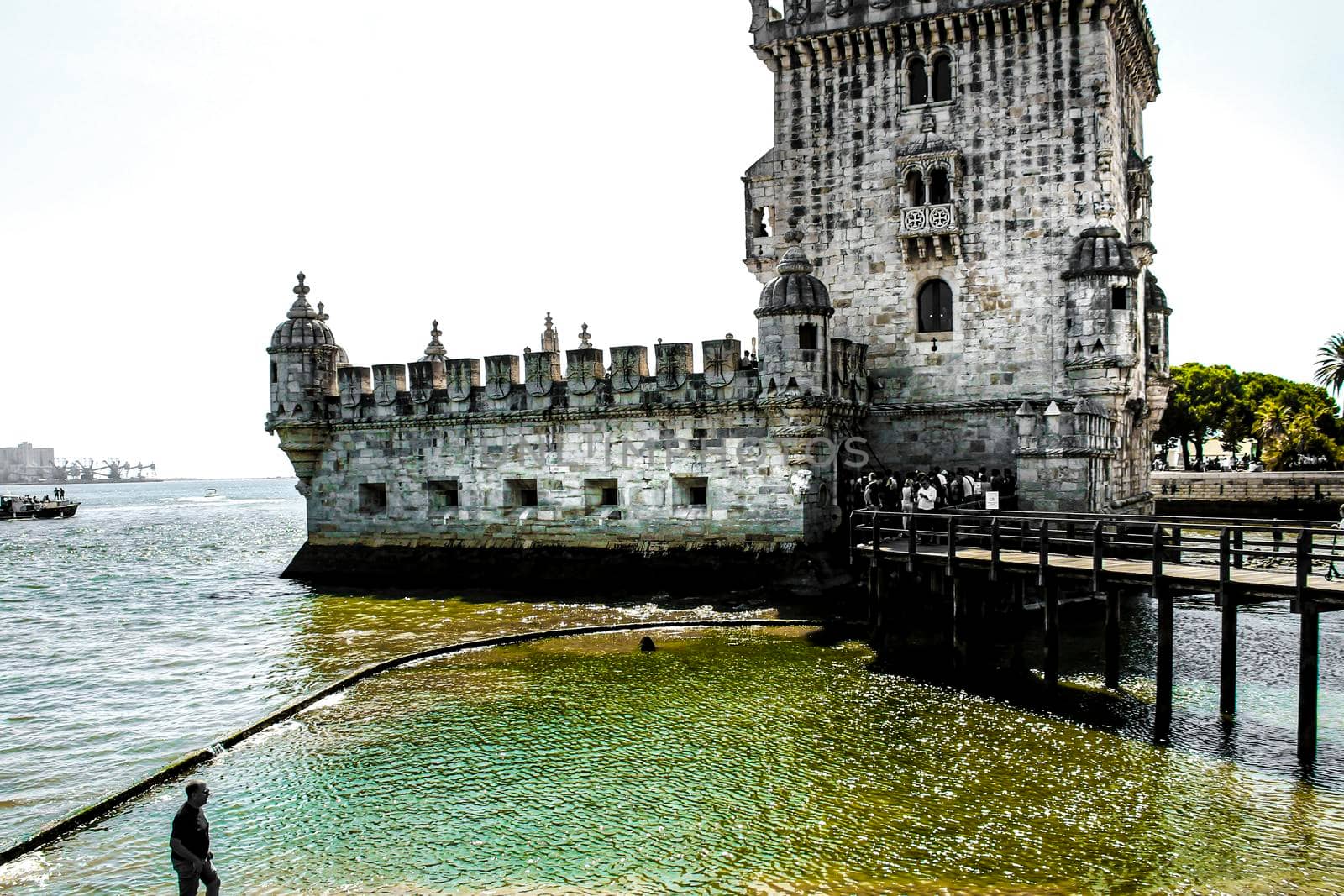 Lisbon, Portugal- 19 May, 2018: Tourists visiting Belem Tower in a low tide day in Lisbon in a sunny day of Spring.