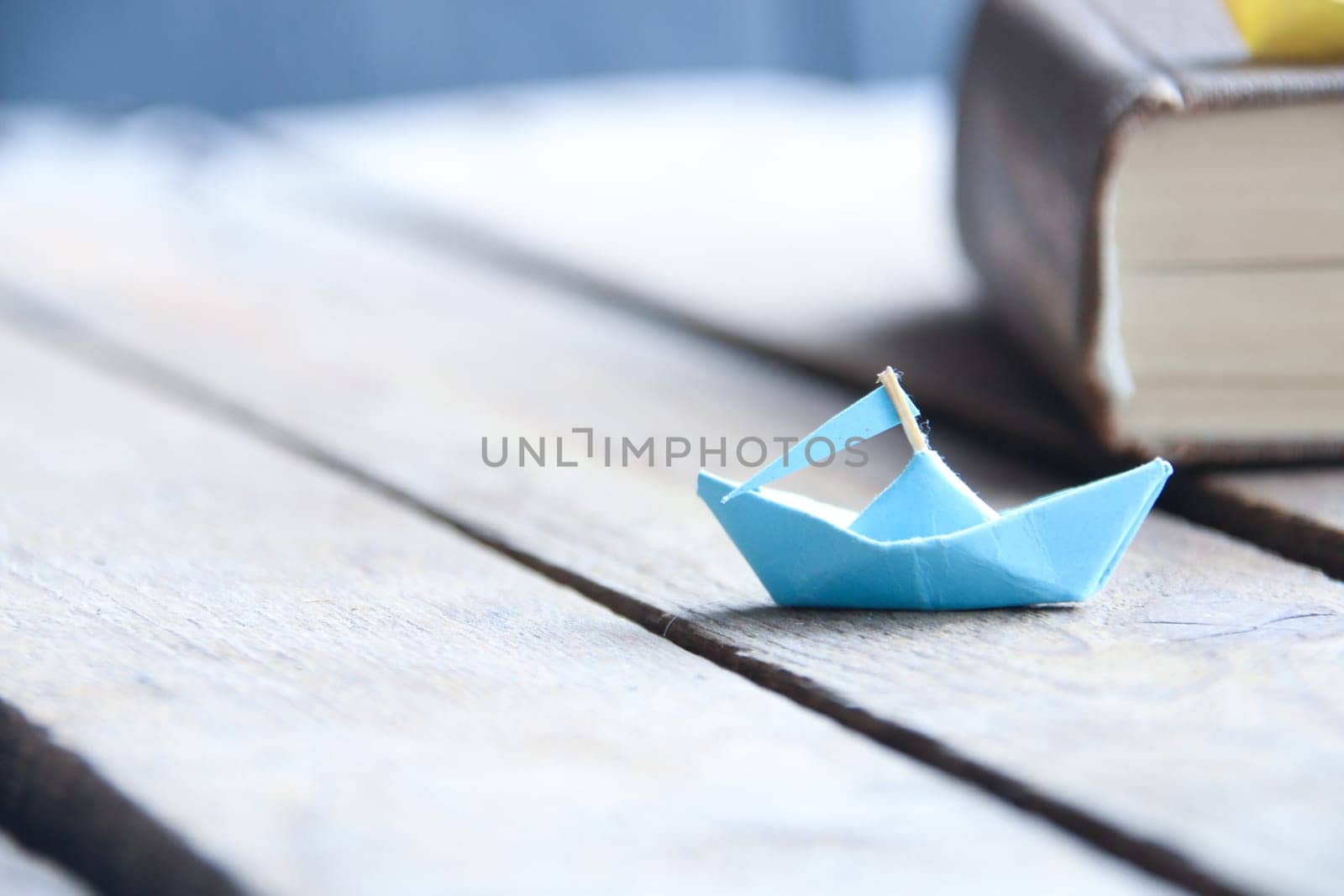 Back to school concept. Paper boat and book.