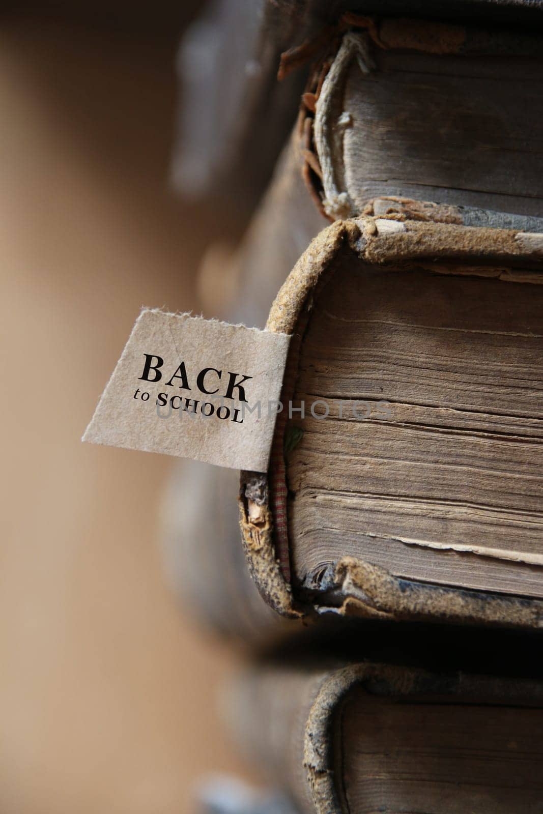 Back to school. Book and tag. Old books on a wooden shelf.