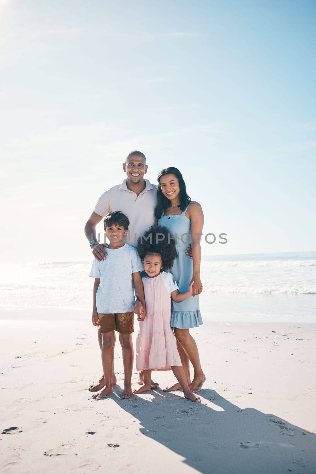 Vacation, beach and portrait of happy family together at the sea or ocean bonding for love, care and happiness. Travel, sun and parents with children or kids on to relax in mockup space on holiday by YuriArcurs