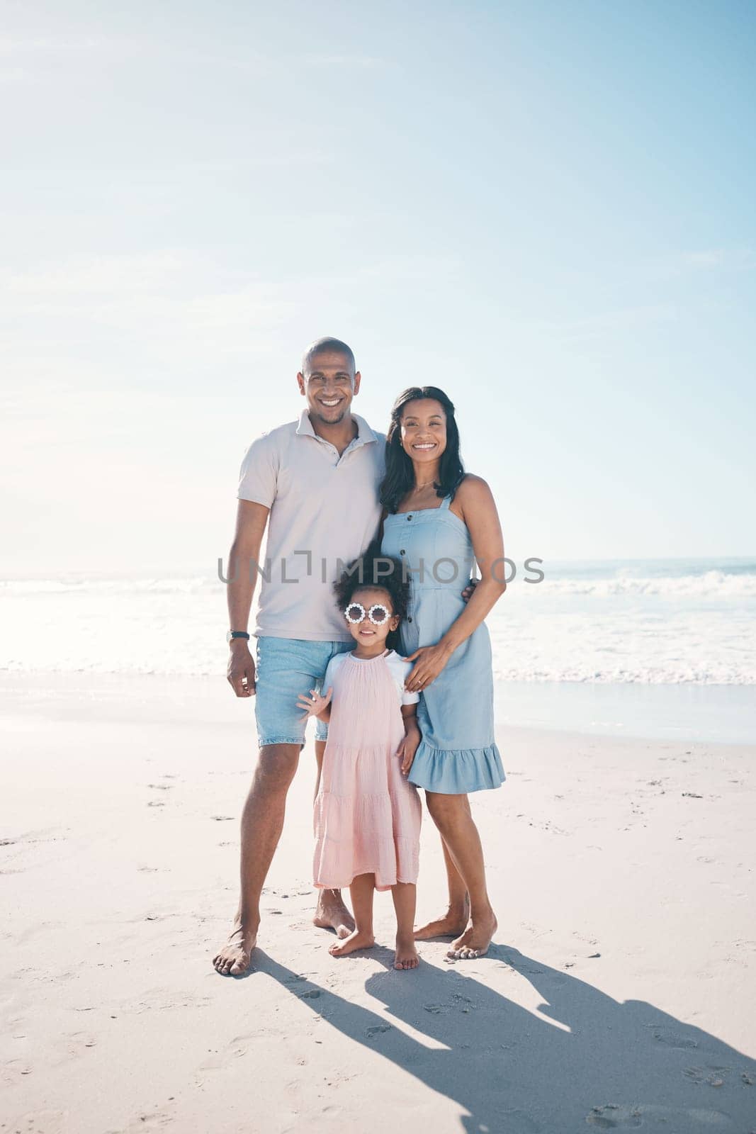 Summer, beach and portrait of happy family together at the sea or ocean bonding for love, care and happiness. Travel, sun and parents with child or kid on to relax in mockup space on outdoor holiday by YuriArcurs