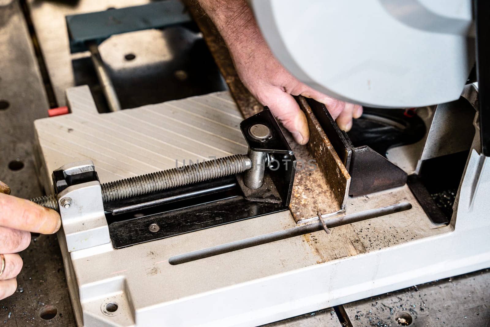 metal saw with tool cutting disc makes a cut. work in home workshop with electric steel cutter machine. Sparks fly from under cutting disc angle grinder. close up.