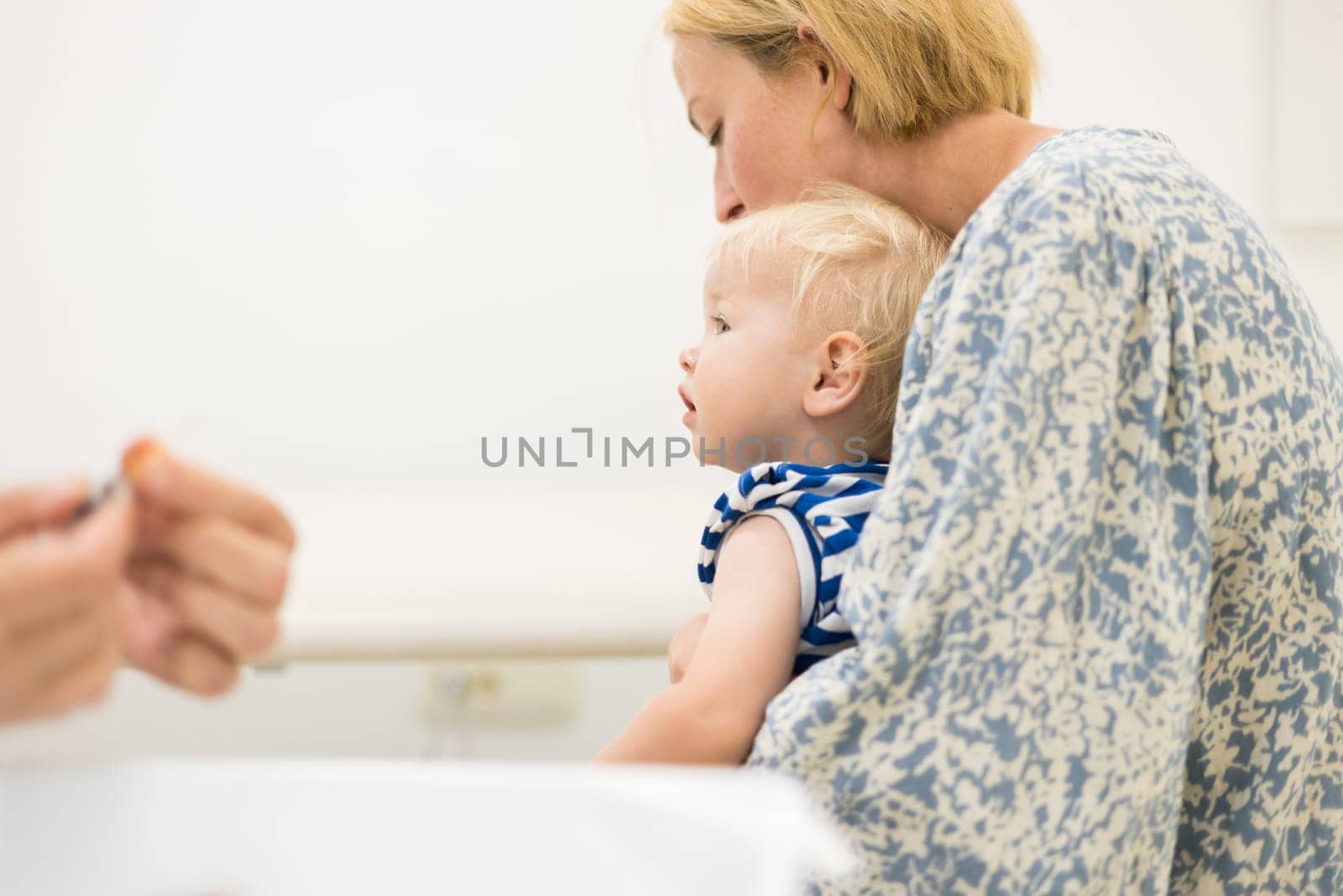 child beeing vaccinated by pediatrician in presence of his mother. Preventive vaccination against Diphtheria, whooping cough, tetanus, hepatitis, haemophilus influenzae, pneumococcus, poliomyelitis.