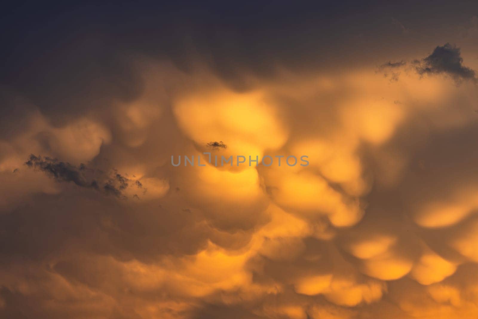 Spectacular yellow clouds in evening sky with weather glow at sunset, Germany