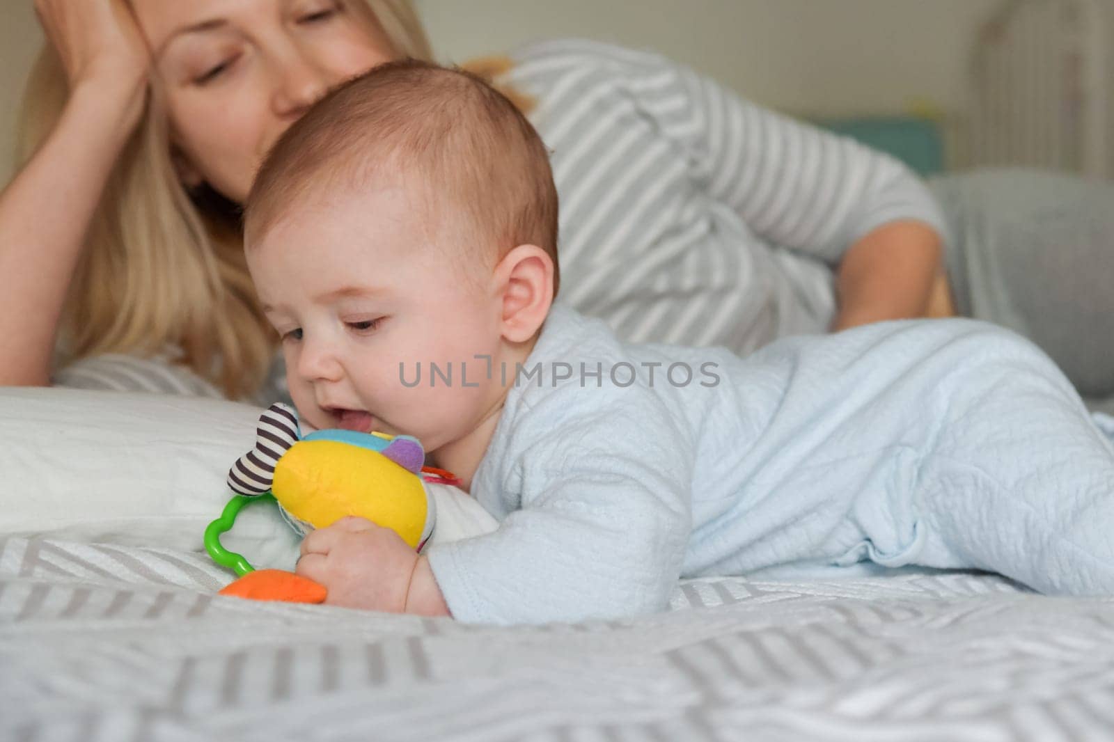 Mother looks at the child as he plays by Godi