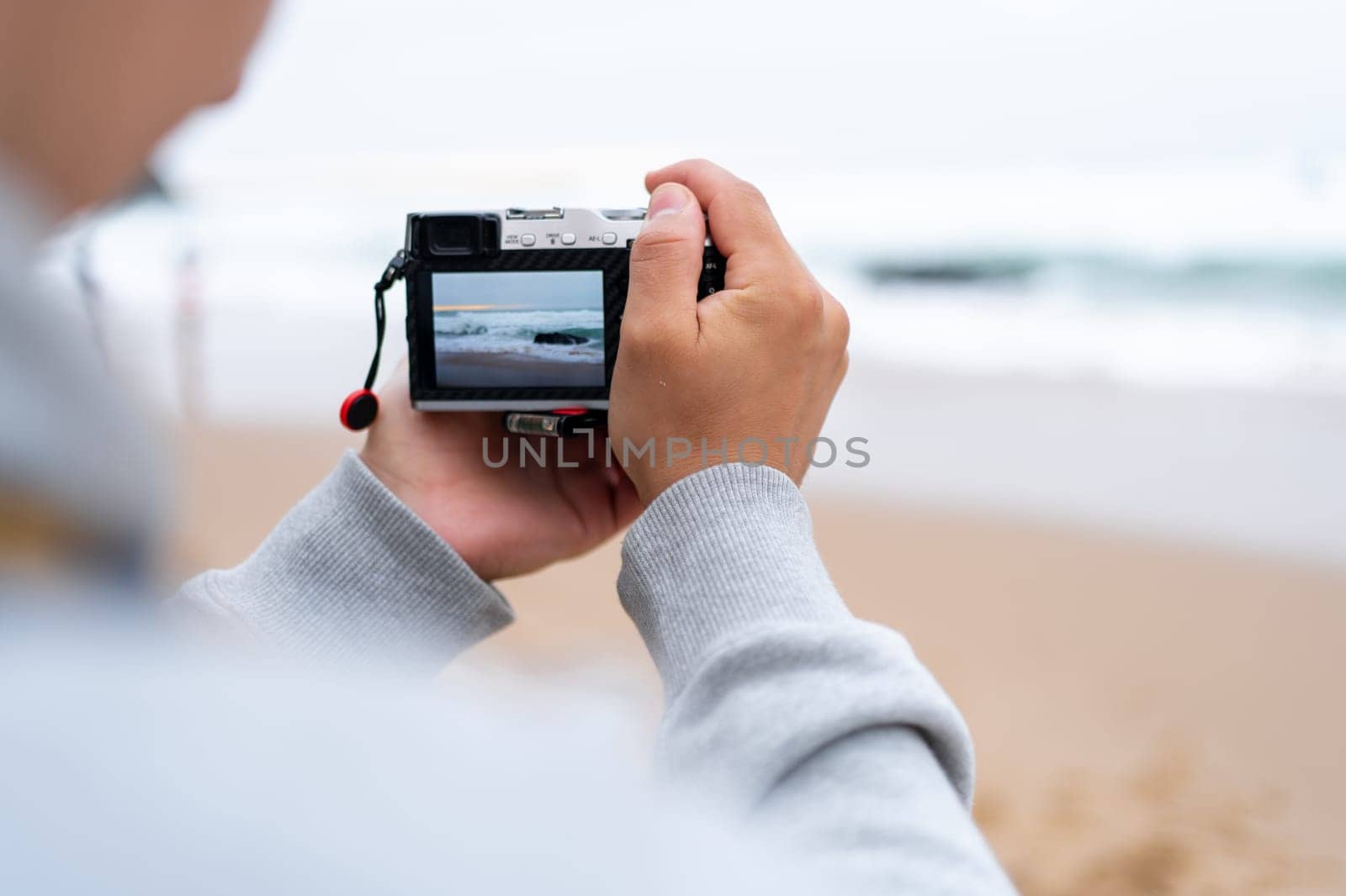 Traveller make photo holding mirrorless camera in hand by andreonegin