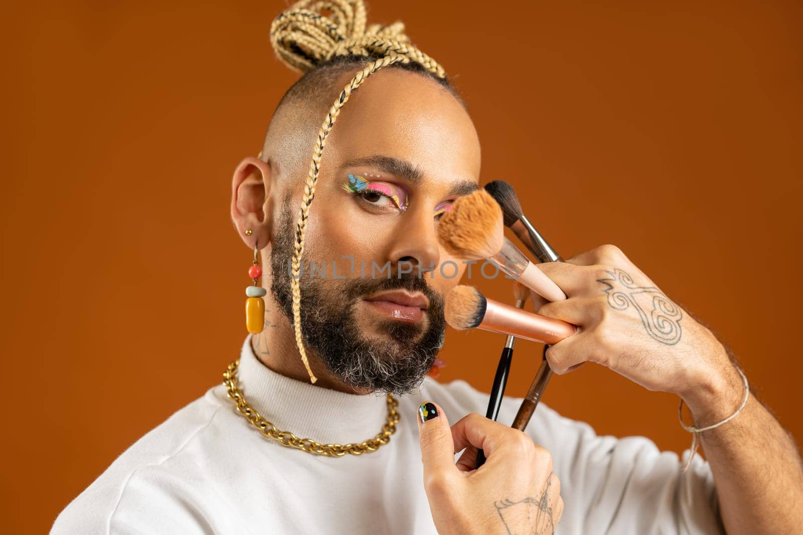 African american gay applying make up isolated on orange background by andreonegin
