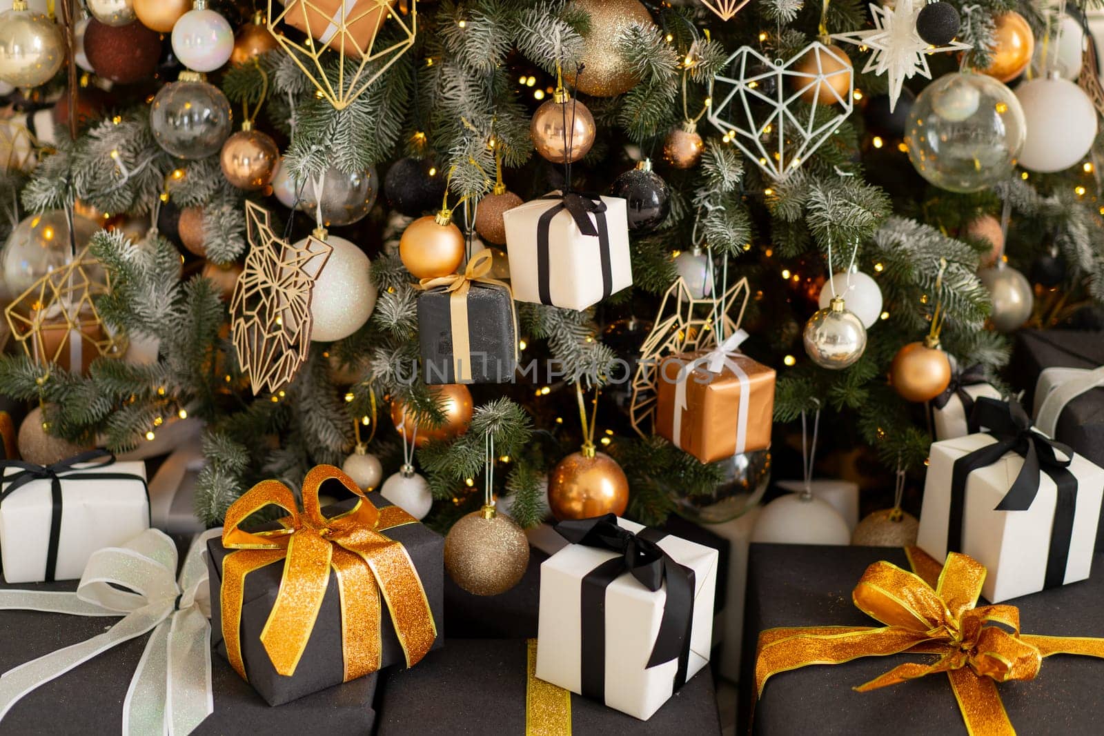 Christmas present gift box stacked close up. Holiday sale concept. Many gift box black, white, orange color with gold ribbon and light garland