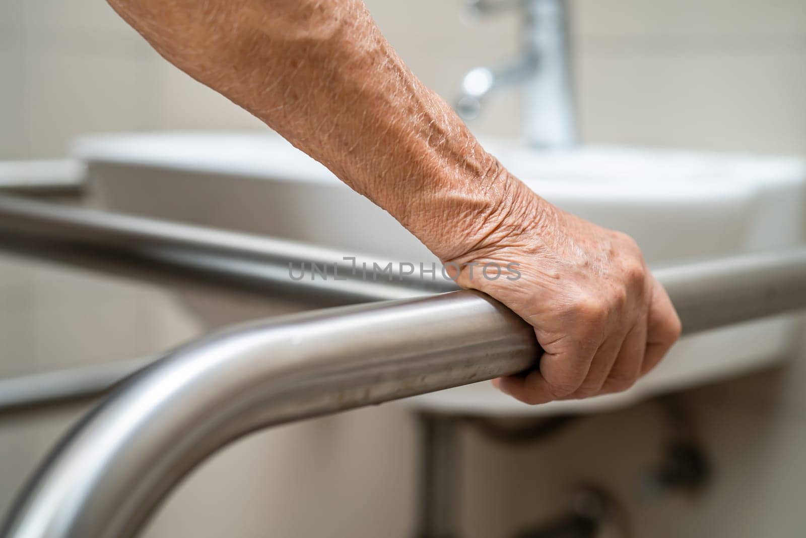 Asian elderly woman use toilet bathroom handle security, healthy strong medical concept. by pamai