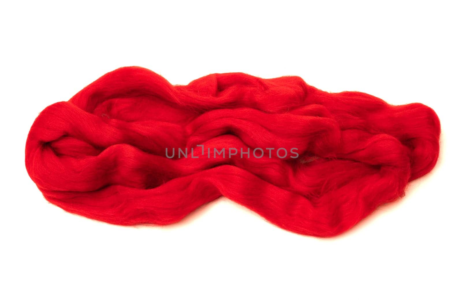 Red merino wool for felting, folded in an abstract pattern on a white background.