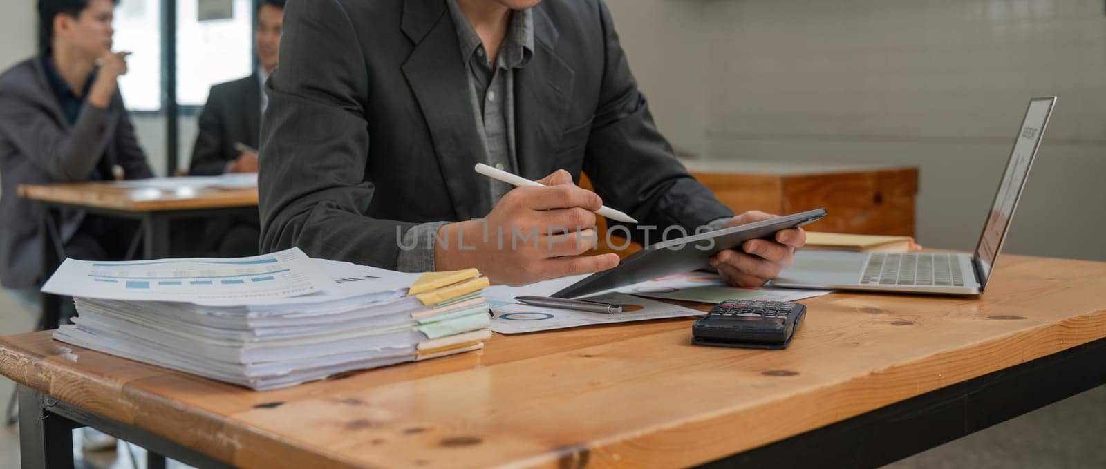Business accounting concept, Business man using calculator with computer laptop and tablet in office.