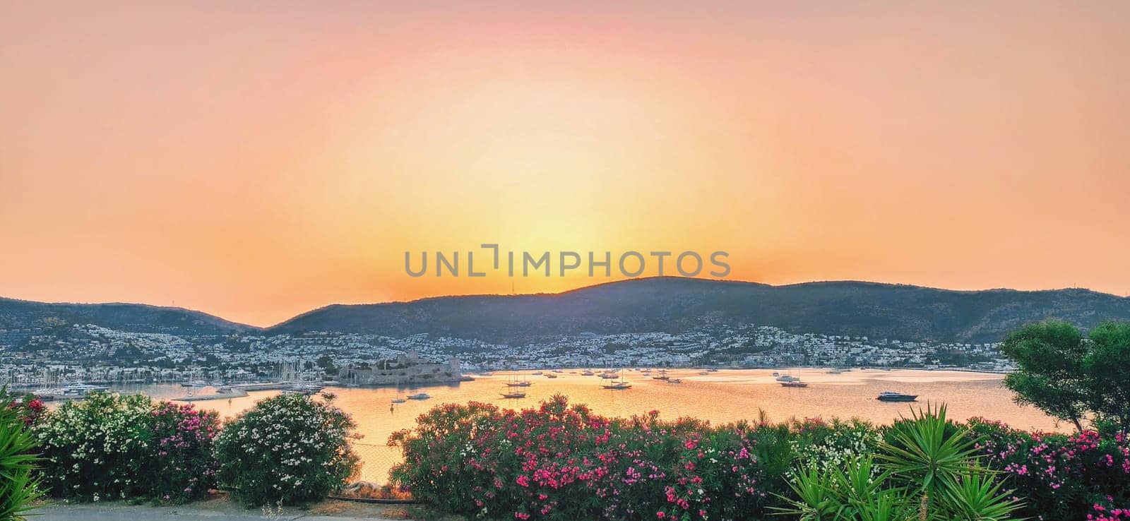 Sunset over mountains and reflection on the sea in the small city Bodrum in Turkey by igor010