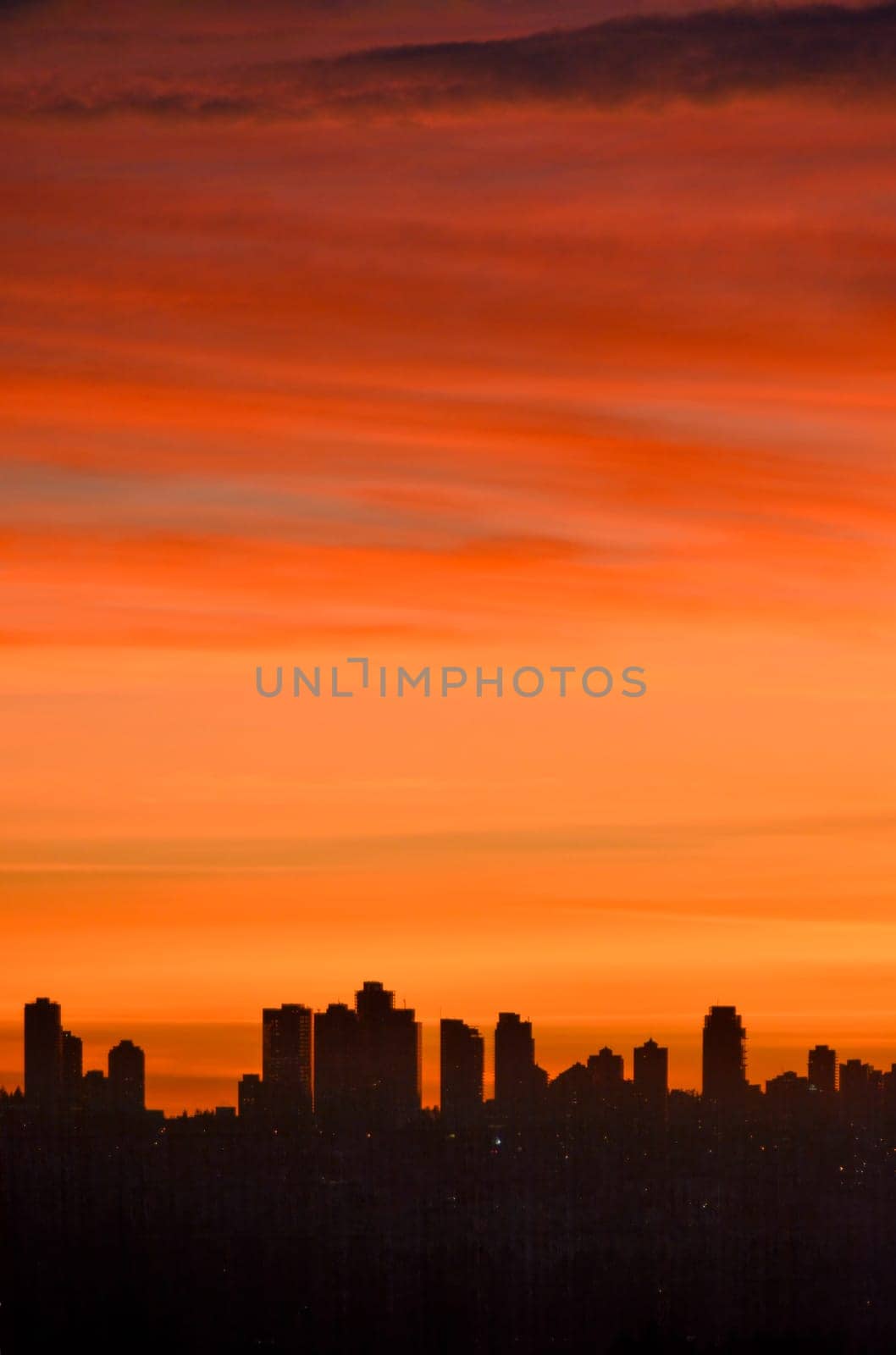 Urban silhouette of buildings on sunset sky background.