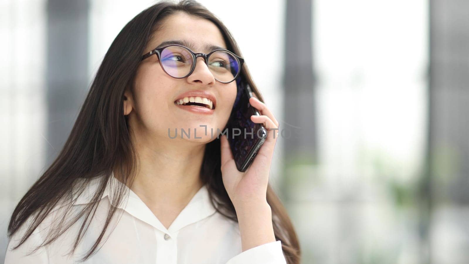 Portrait of young business woman with glasses ofand talking on mobile phone