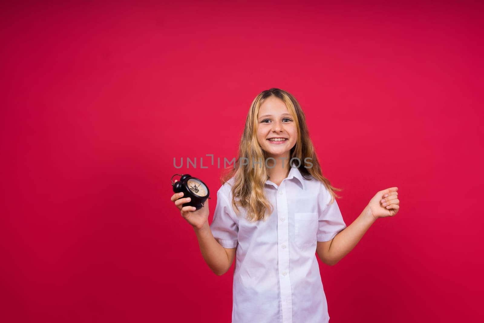 Teen girl 12, 13, 14 years old look alarm clock. Good morning, checking time. Positive emotions.