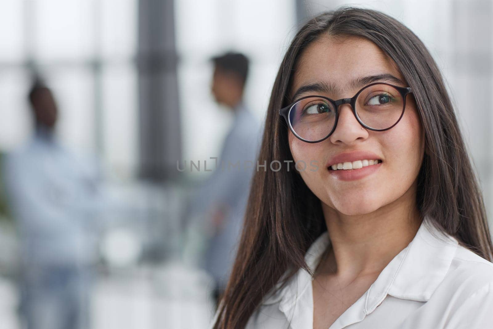 a girl stands in a modern office and looks at the camera