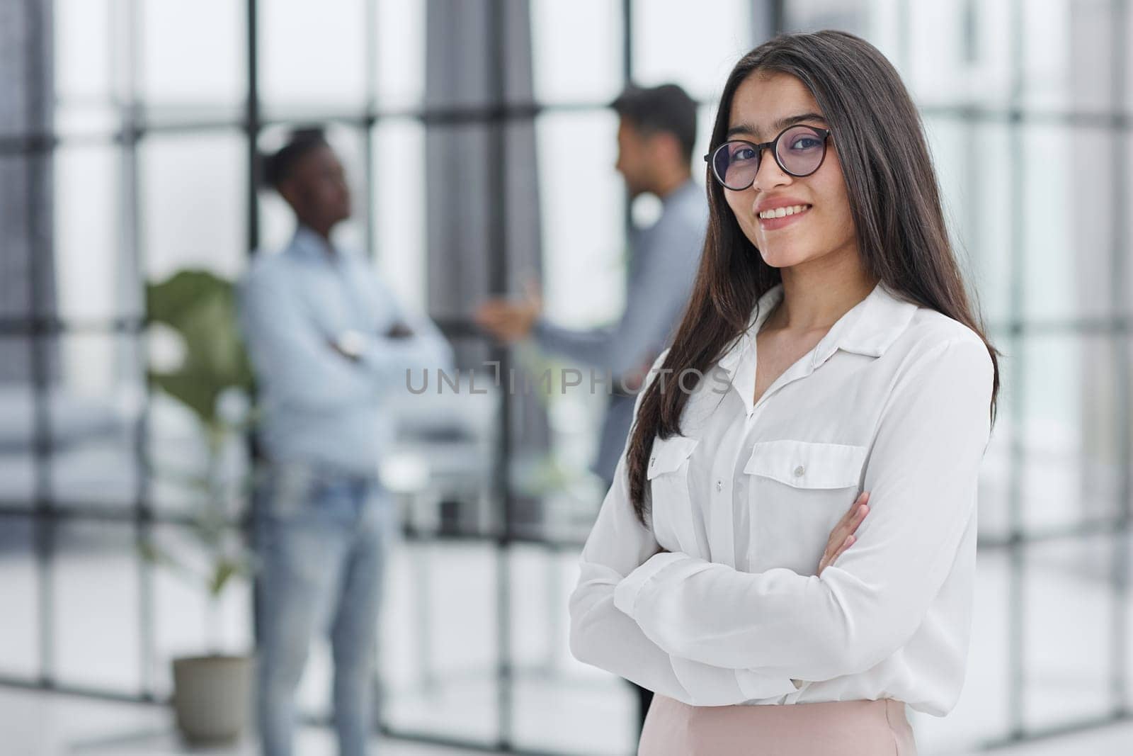 a girl stands in a modern office and looks at the camera