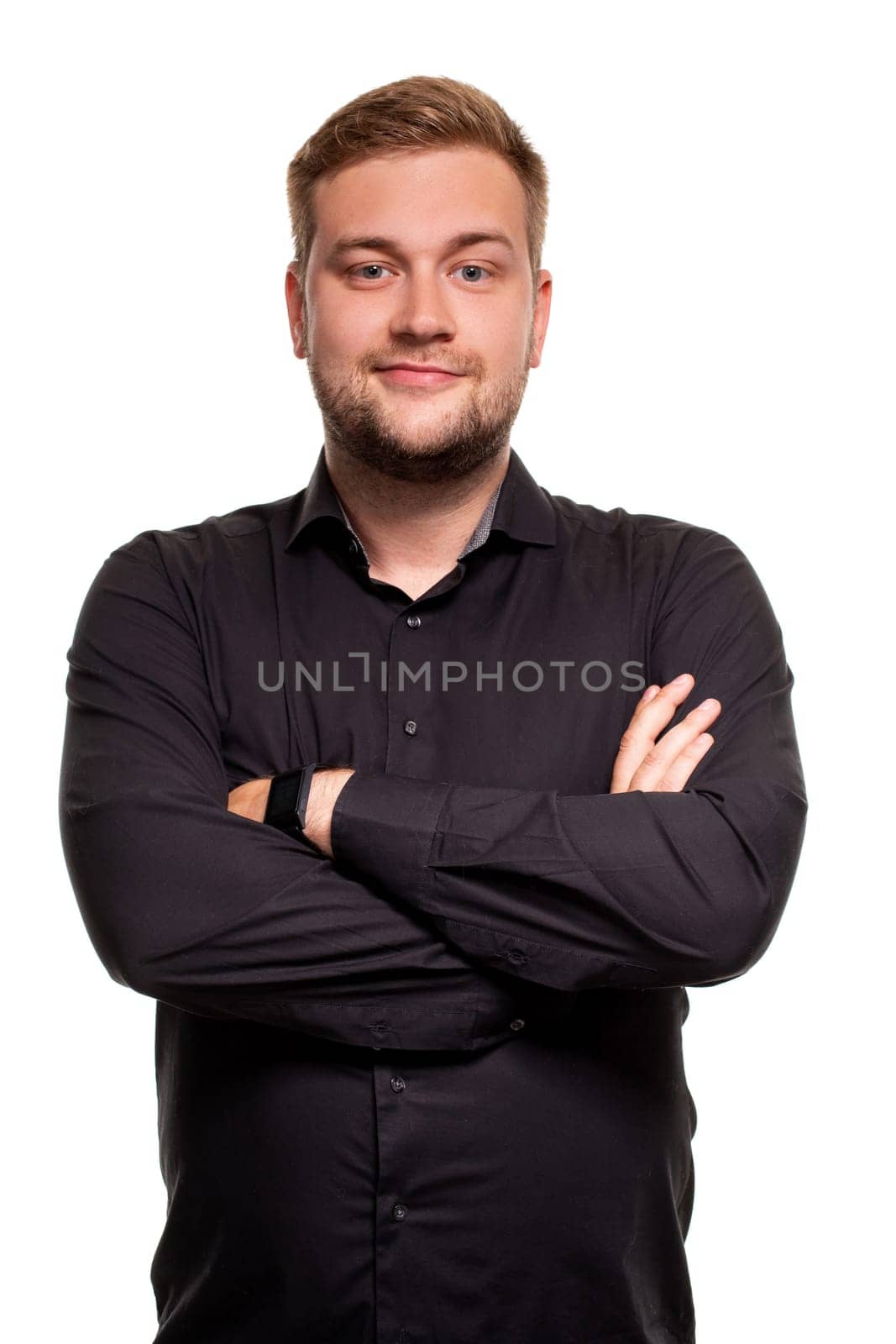 Young man in black shirt is smiling and crossed his arms over chest against white background by nazarovsergey