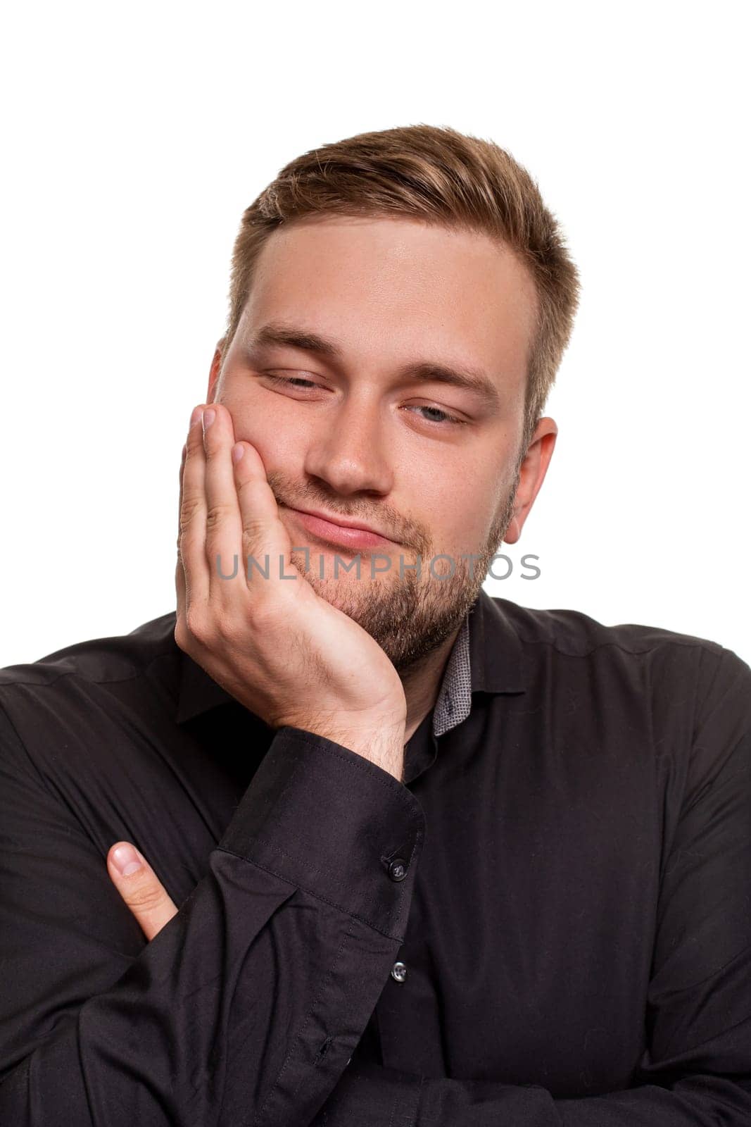 Studio portrait of gloomy european man showing boredom while leaning head on hand and standing over white background. by nazarovsergey