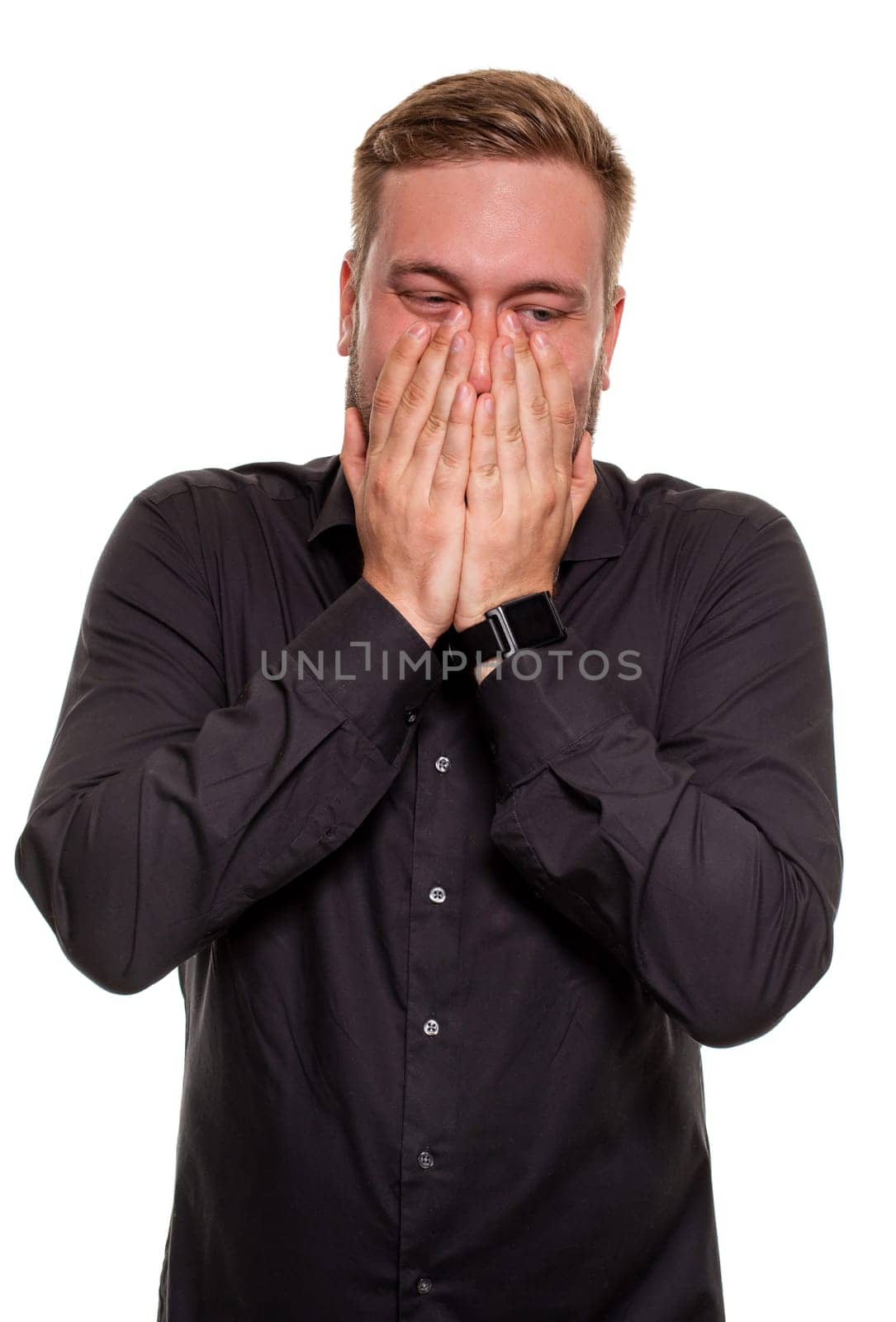 Portrait of man in black shirt holding palms near cheek. Facial expressions and reaction concept