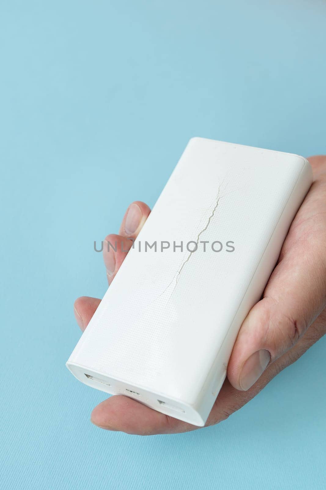 Power bank in hand, a battery that has become unusable, expands and swells until the case breaks. There is a risk of explosion