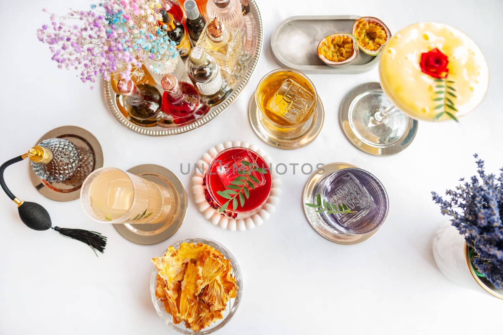 Five colorful summer cocktails in glasses on white table. Assortment of fresh summer drinks. Orange and red sangria cocktails, orange punch cocktail, margarita cocktail, tropical mule.