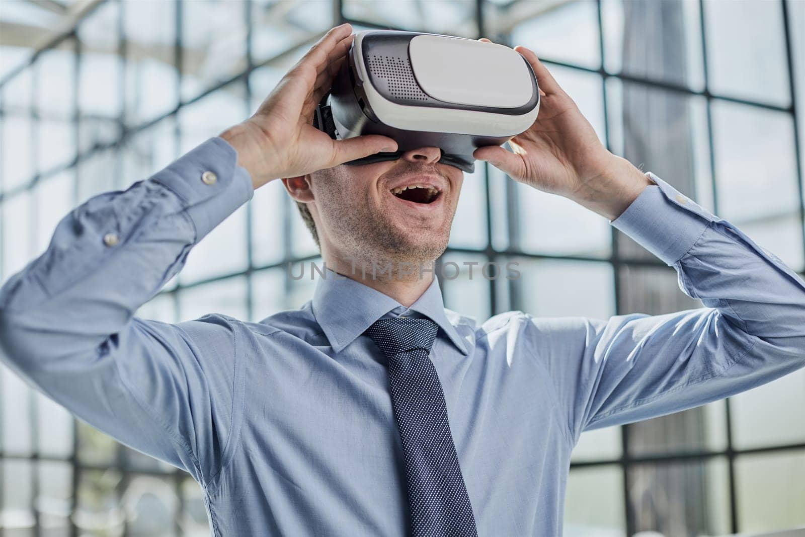young man testing VR glasses or goggles sitting in the office room