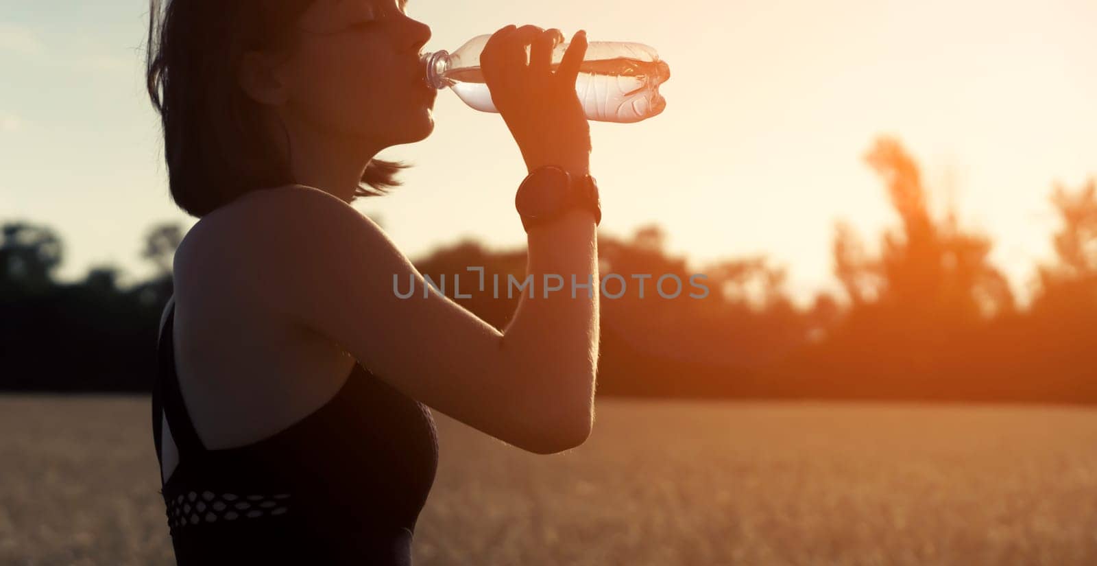 Girl drinks water from a bottle during her training. by africapink