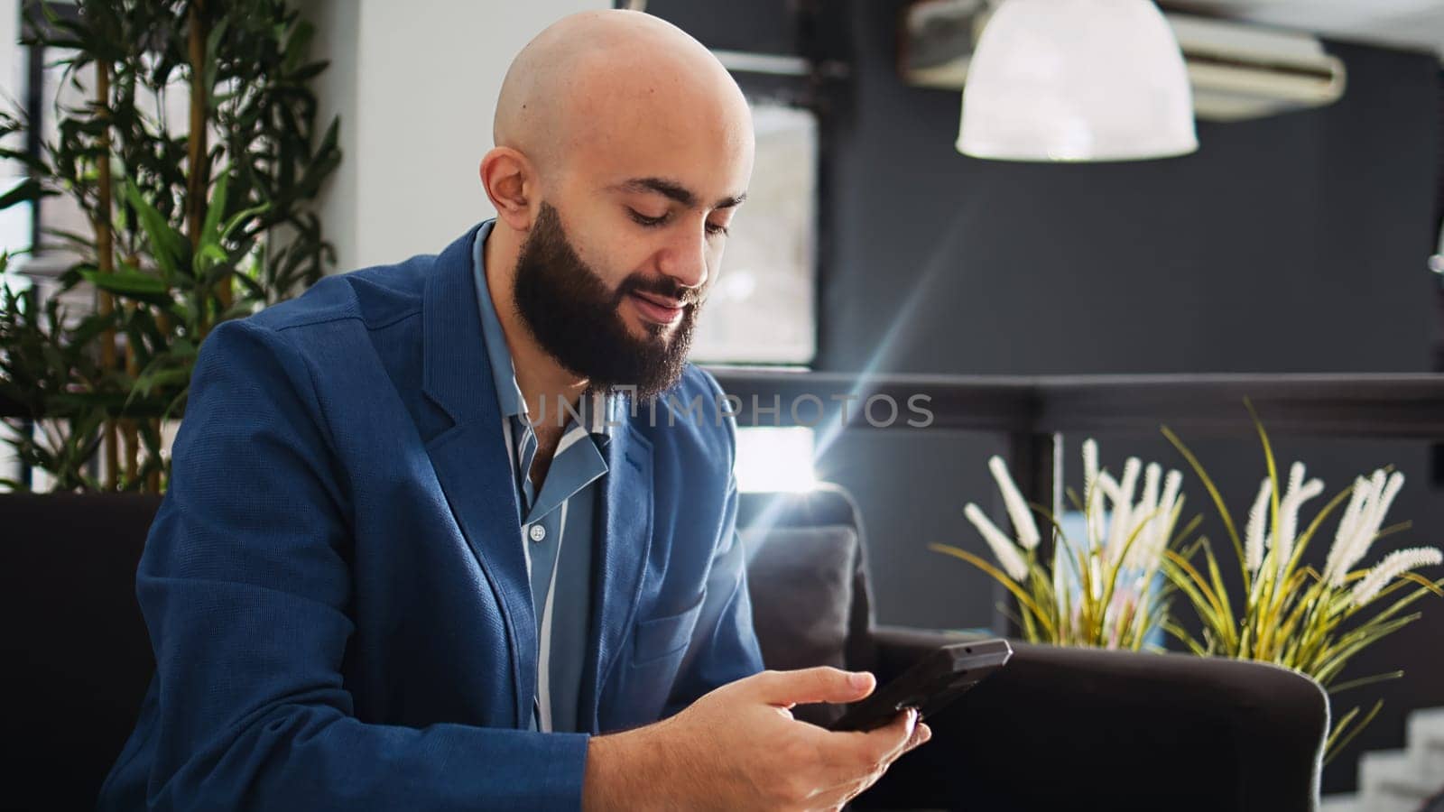 Manager examine sales statistics in startup business coworking space, looking at annual data reports on smartphone. Employee analyzing company information in office, successful entrepreneur.