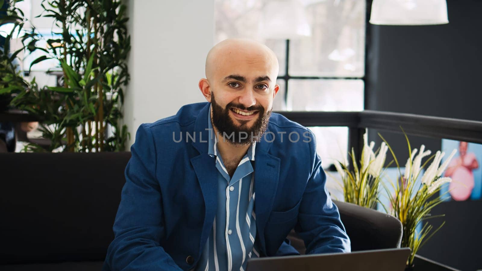 Startup worker uses laptop in open space, reviewing project data on documents at workstation. Executive assistant working on marketing strategy for business development, AI developer.