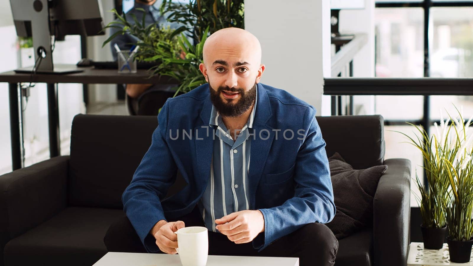 Man attends business meeting videocall to review new development strategy, using online telework call with marketing department. Startup executive manager in office coworking space. Tripod shot.