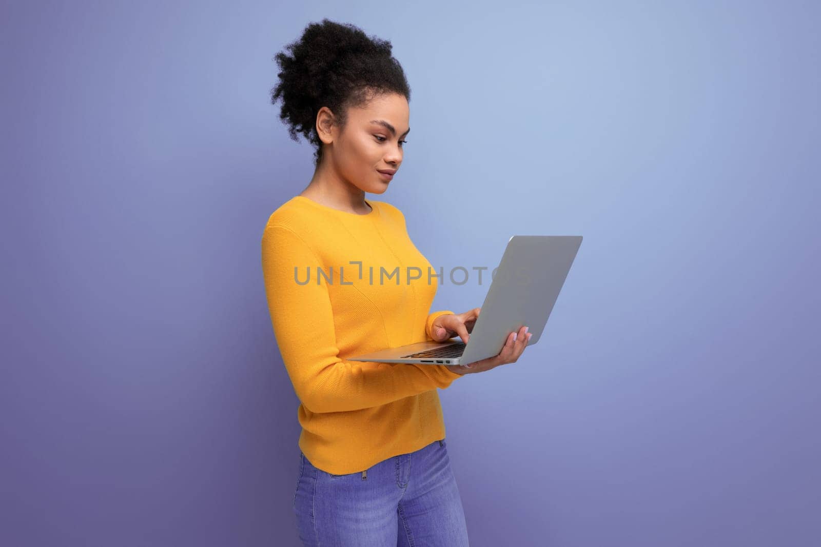 confident smart young 25 year old hispanic business lady with afro with a laptop in her hands.