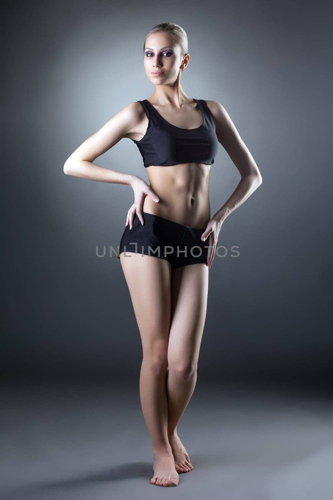 Studio shot of comely sporty woman posing at camera