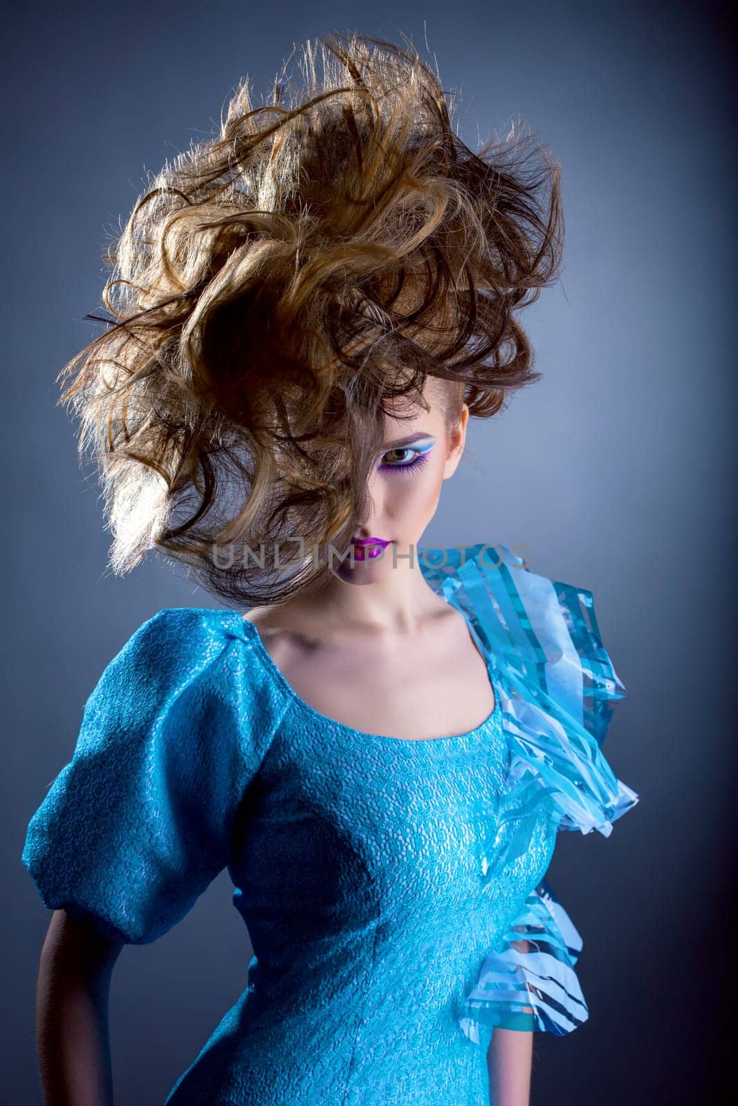 Pretty woman with creative hairdo looking at camera