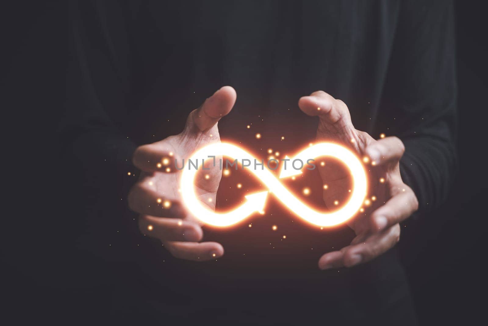 Businessman holds circular infinity symbol on dark background, representing circular economy and infinite possibilities. Strategy of sustainable investment, banking, and financial growth.