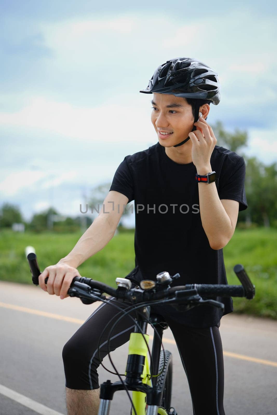 Man listening music through earphones and riding bicycle in sunny summer day. Active sporty, people and healthy lifestyle concept by prathanchorruangsak