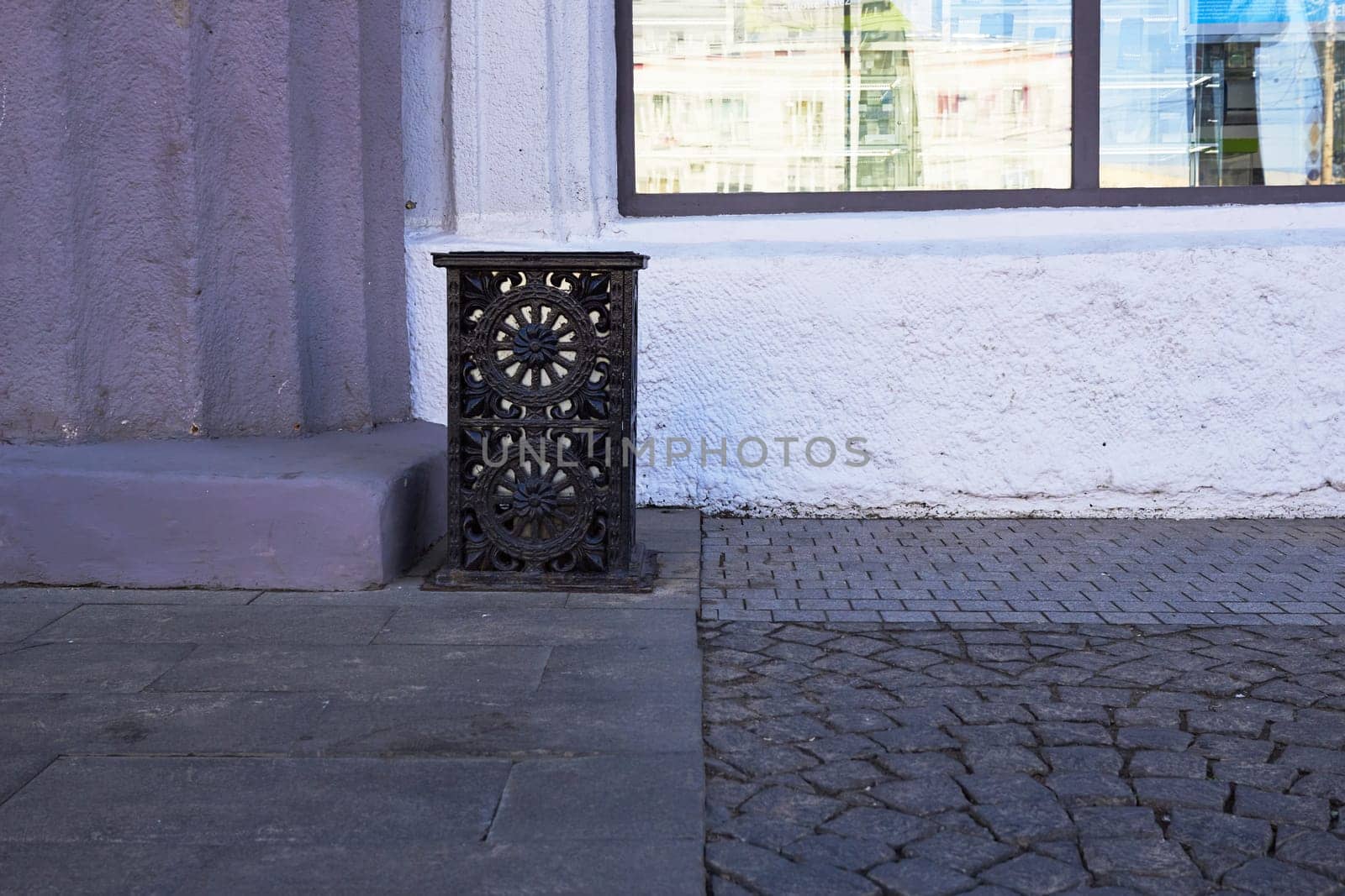 Photo of forged black trash can on street. Cleaning. Maintaining cleanliness. Urban space.