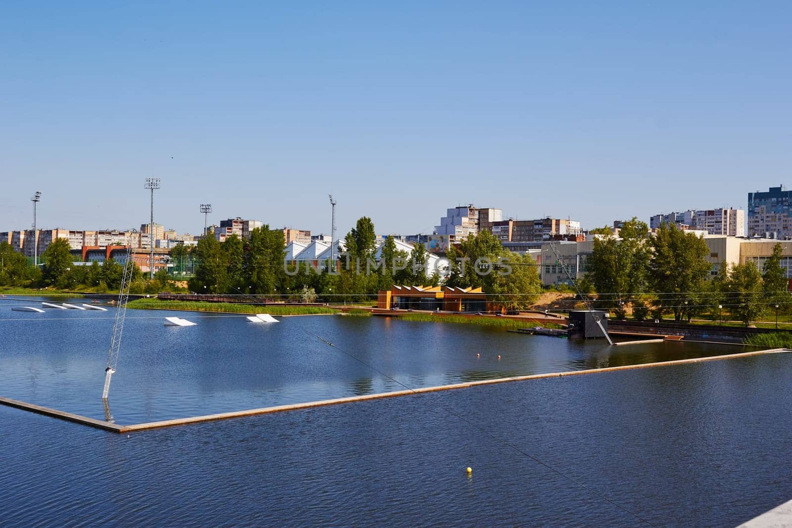 Photo of lake in middle of high-rise buildings. Space for water sports. Outdoor sports.