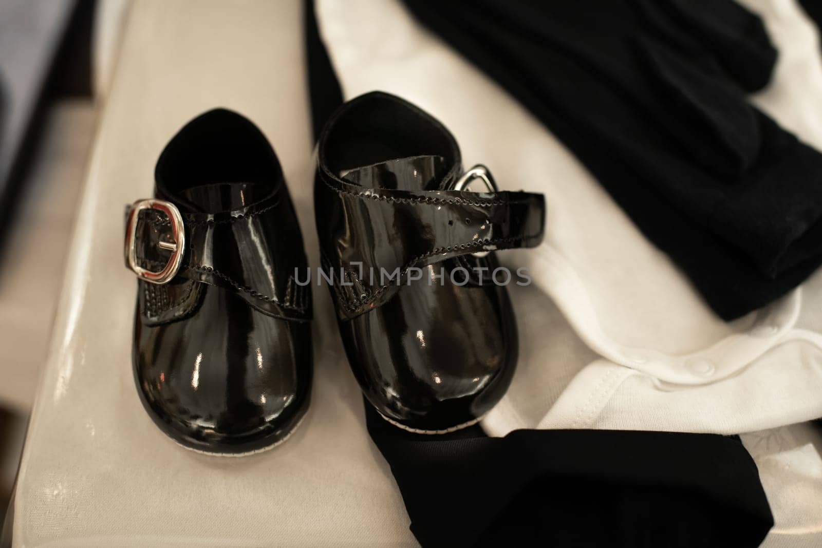 Patent leather shoes for a baby in a church for christening ready for baptism
