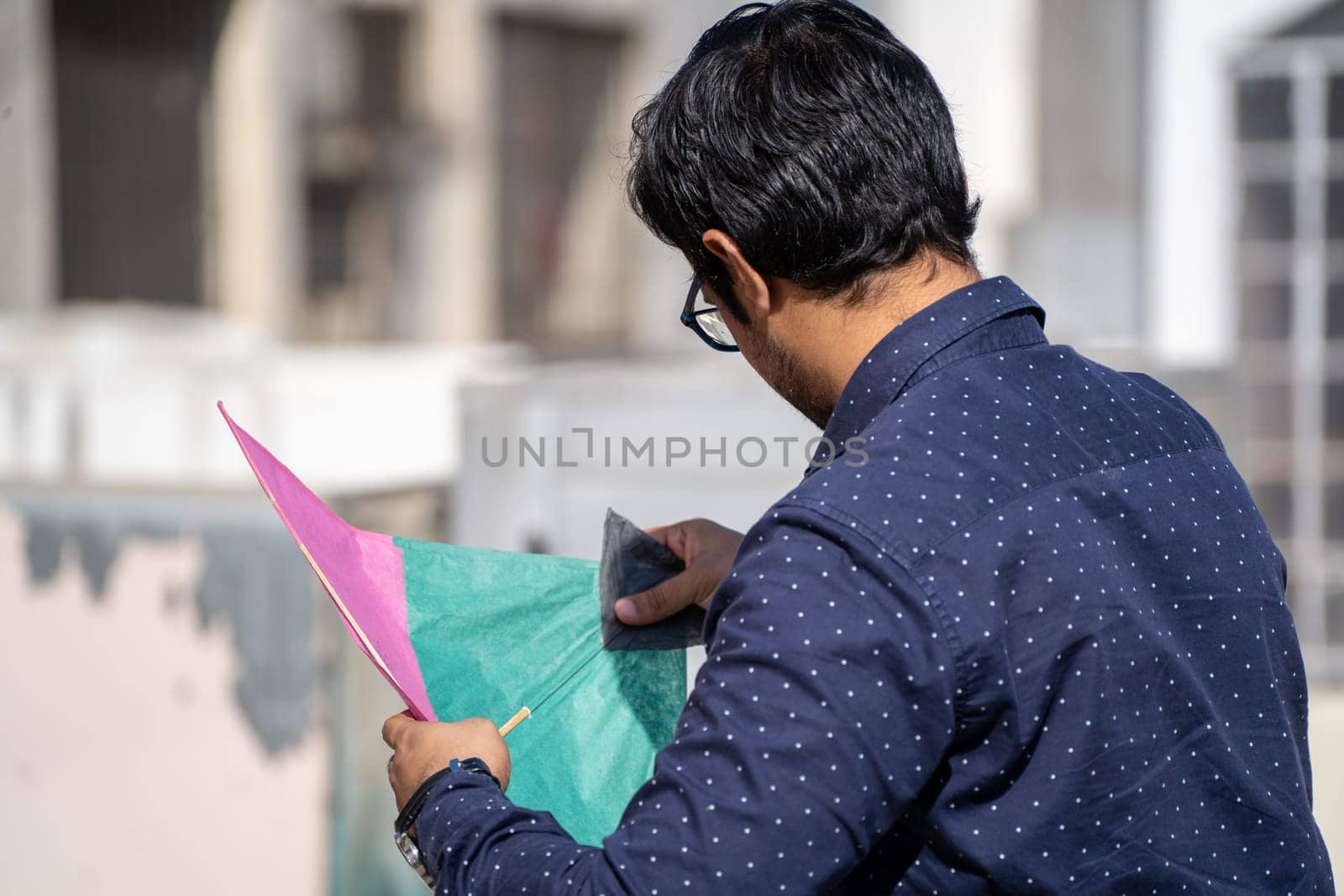 Man preparing kites for flight on makar sankranti uttarayan independence day india showing the celebrations by Shalinimathur