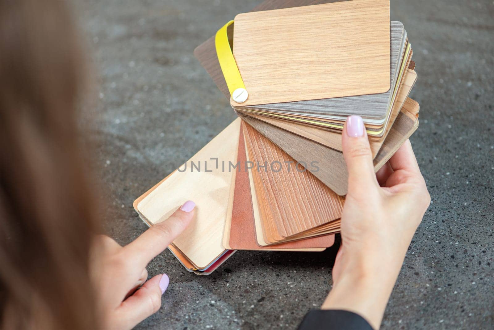 laminate samples. The choice of laminated surface for chipboard. Samples of wood imitation laminate in hands, close-up. High quality photo