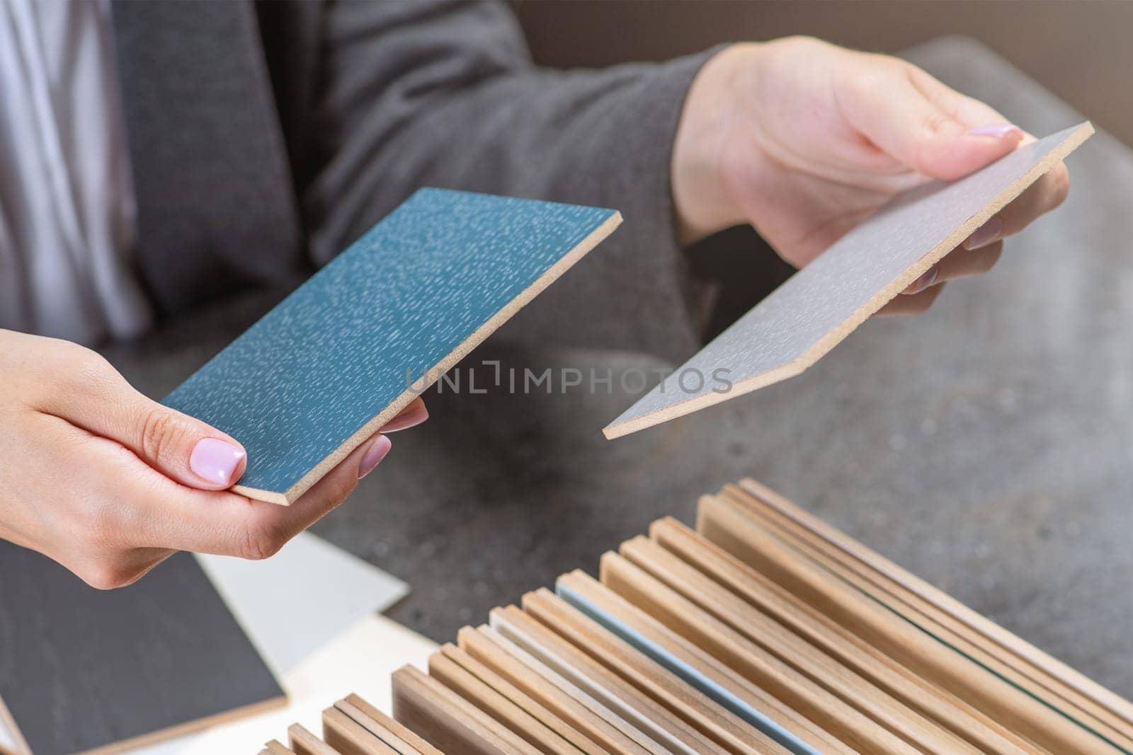 Samples for gender selection. A woman selects pieces of colored wood to choose a gender. The concept of repairing or laying a new flooring. High quality photo