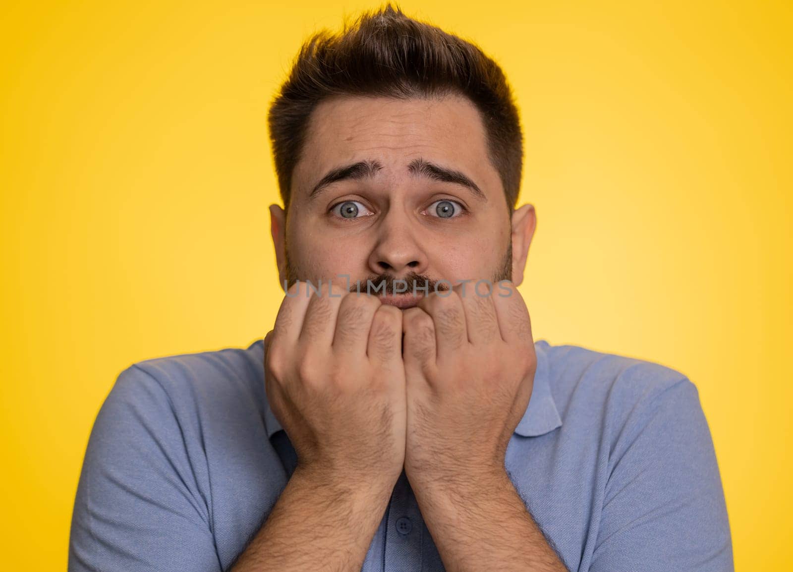 Stressed depressed caucasian man terrified about danger problems, suffering phobia, anxiety disorder, expresses fear, waving no, insecure, stress, panic. Young guy isolated on yellow studio background