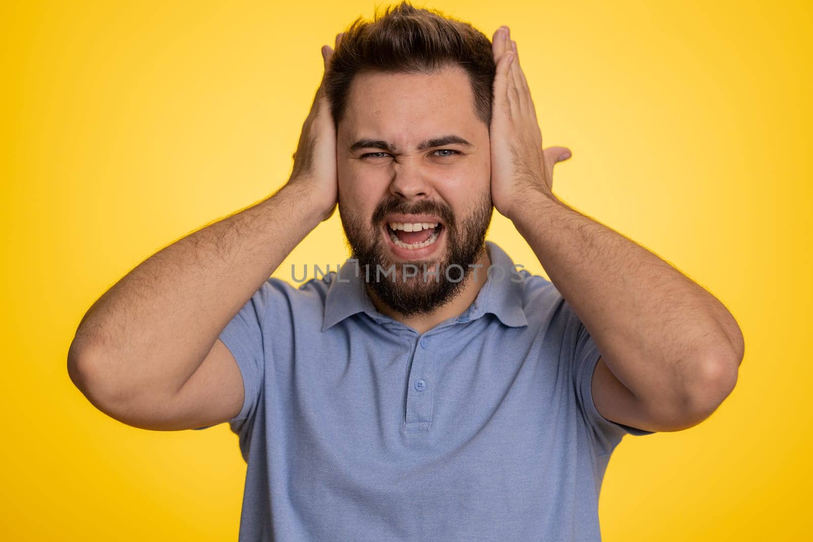Dont want to hear and listen. Frustrated annoyed irritated caucasian man covering ears gesturing No, avoiding advice ignoring unpleasant noise loud voices. Handsome guy alone on yellow background