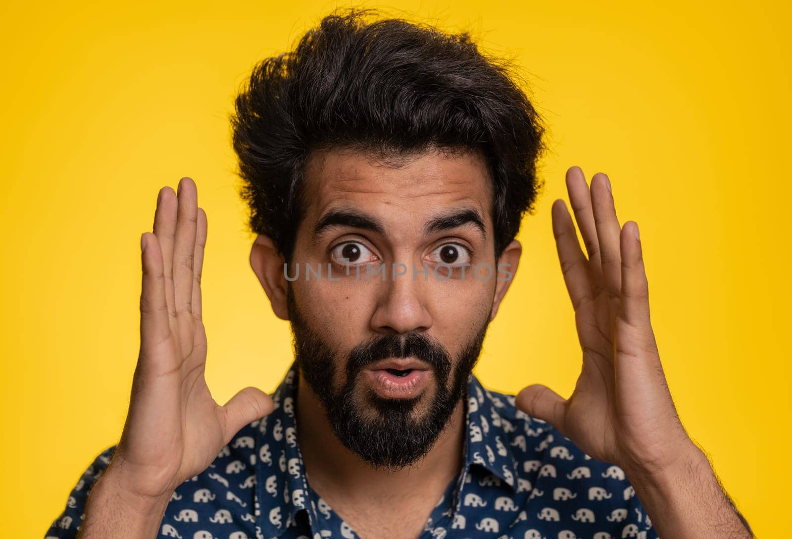 Oh my God, Wow. Excited amazed winner man surprise looking at camera with big eyes, shocked by sudden victory. Sincere confused shocked handsome indian guy isolated alone on yellow studio background