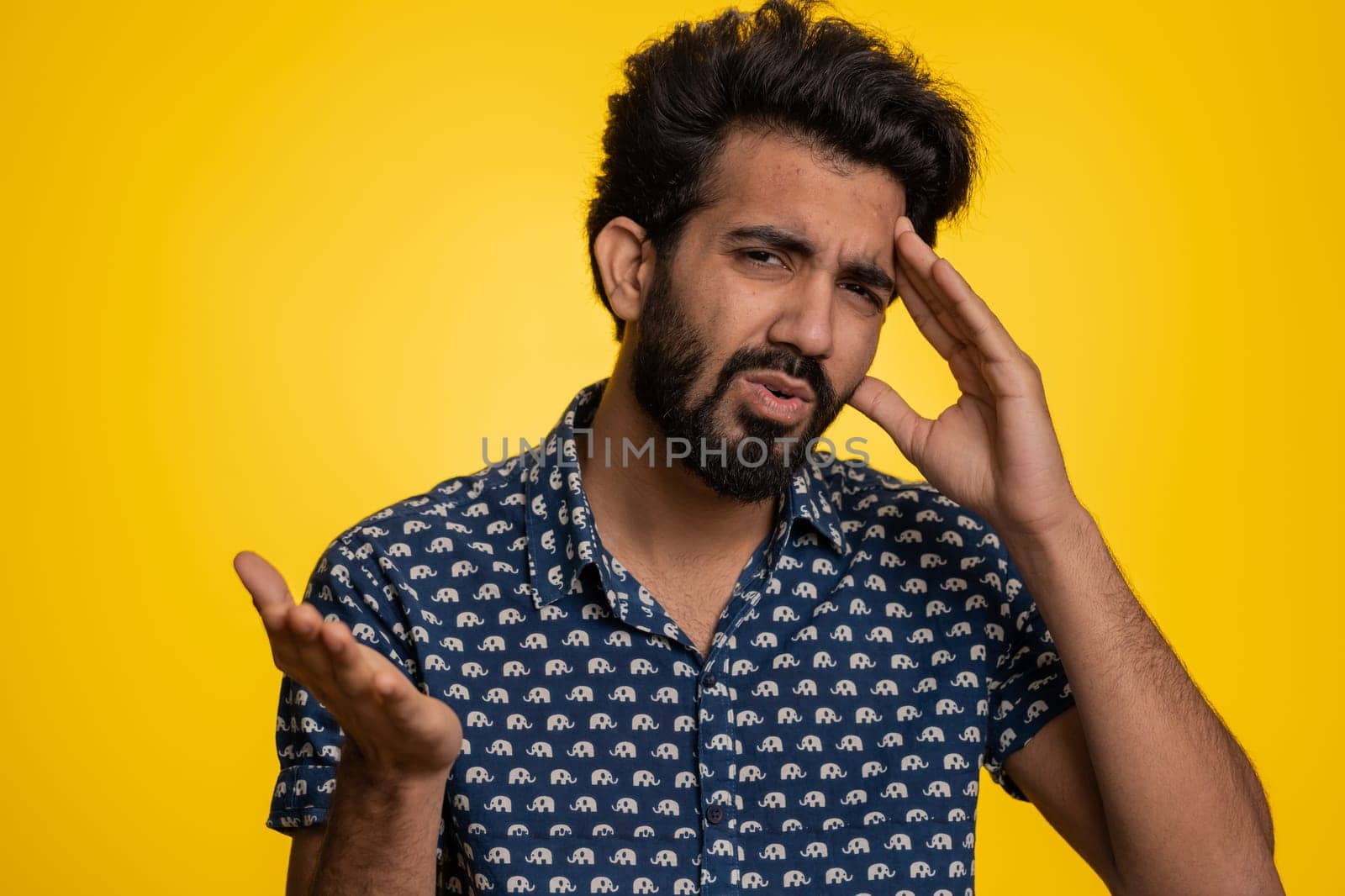 Bearded indian man feeling hopelessness loneliness, nervous breakdown, loses becoming surprised by lottery results, bad fortune loss, unlucky news. Hindu young guy isolated on studio yellow background