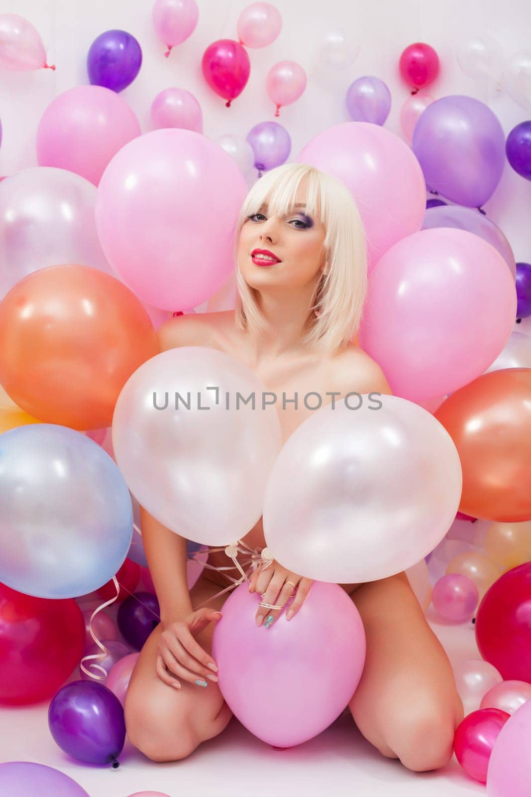 Sexy platinum blonde posing with colorful balloons