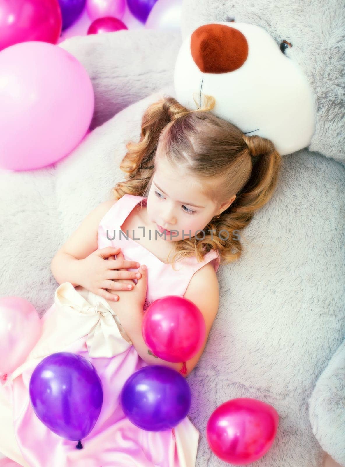 Tired girl posing lying on big teddy bear, close-up