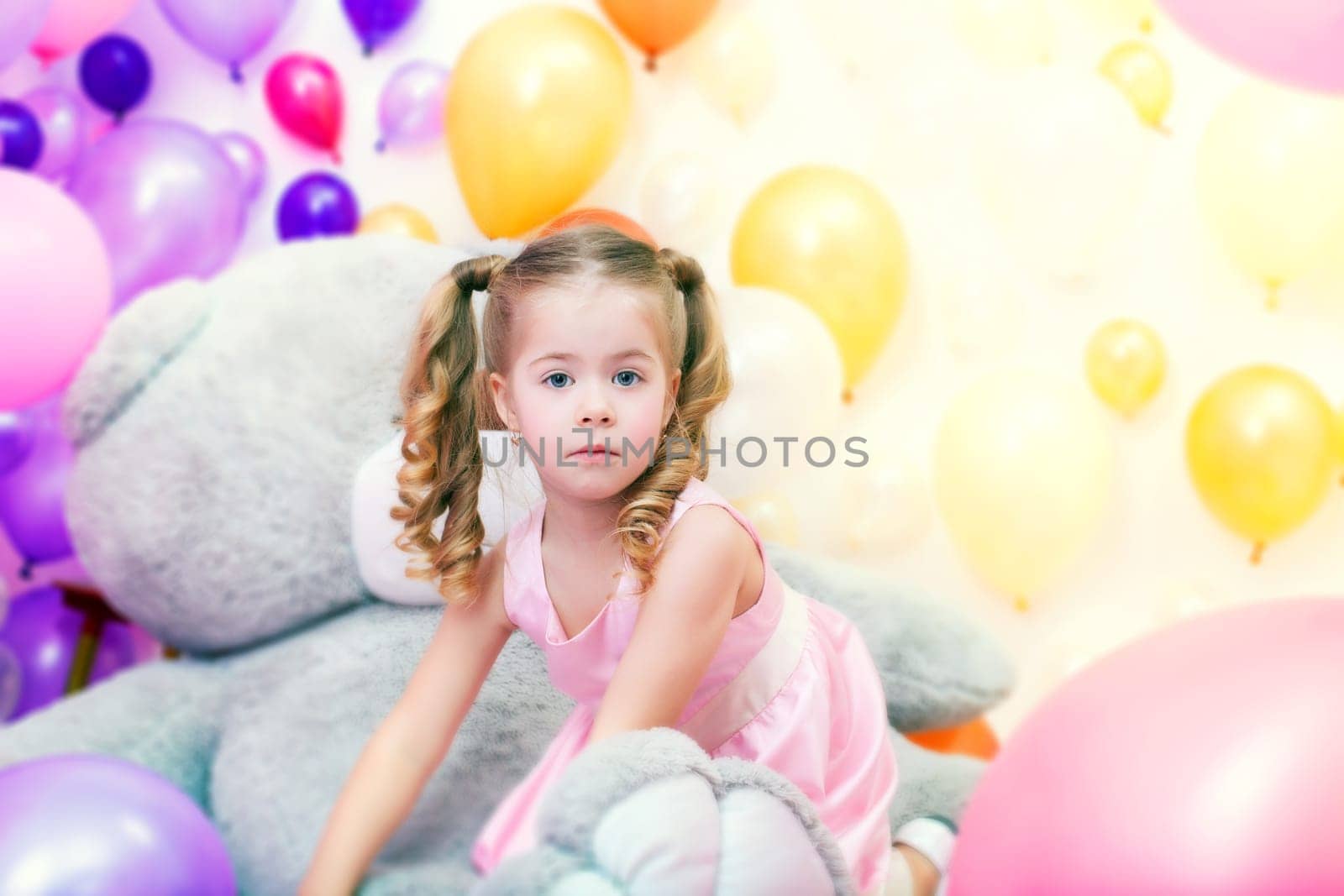 Image of funny little girl playing in studio with balloons