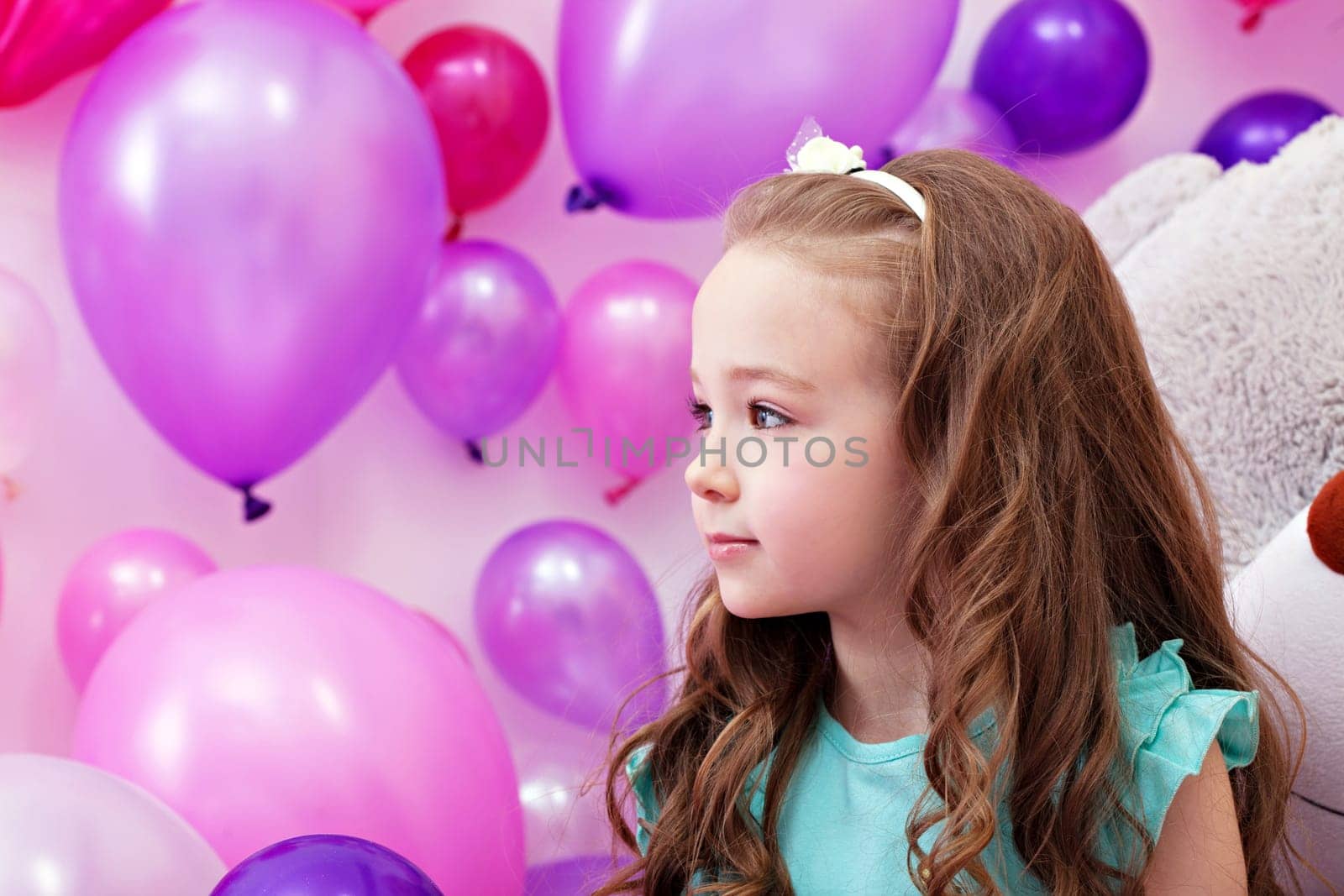 Beautiful young girl posing on background of balloons